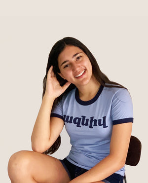 Seventies inspired Armenian written t-shirt on a pretty girl with beautiful smile. A blue ringer t-shirt that says azniv TK-LA